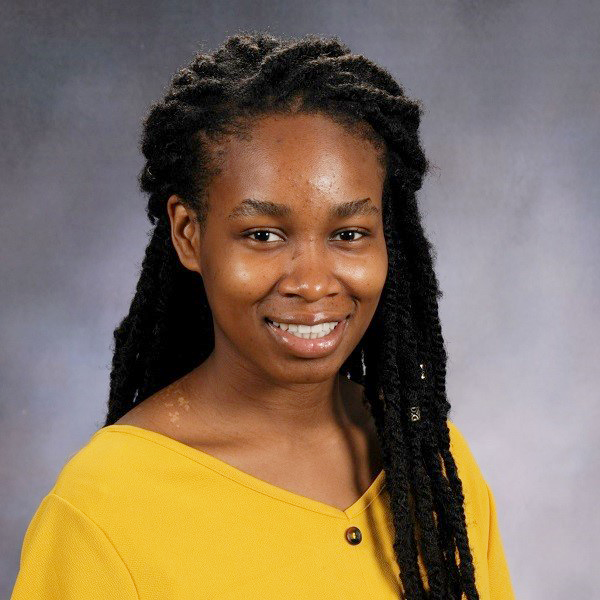 Gloria Ashaolu in a yellow shirt against a gray background