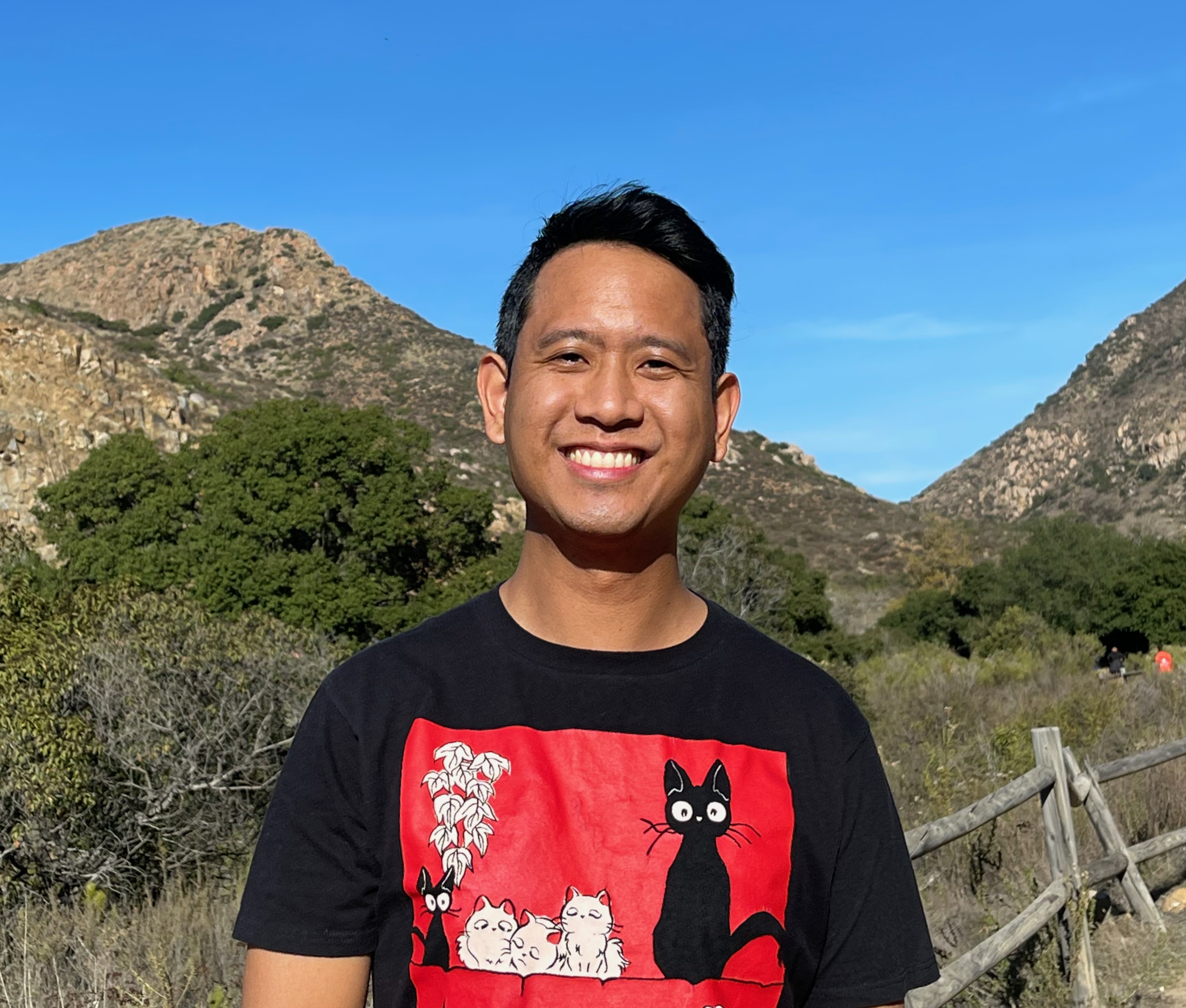 Lee Melvin Peralta in a red-and-black shirt against a mountain background.