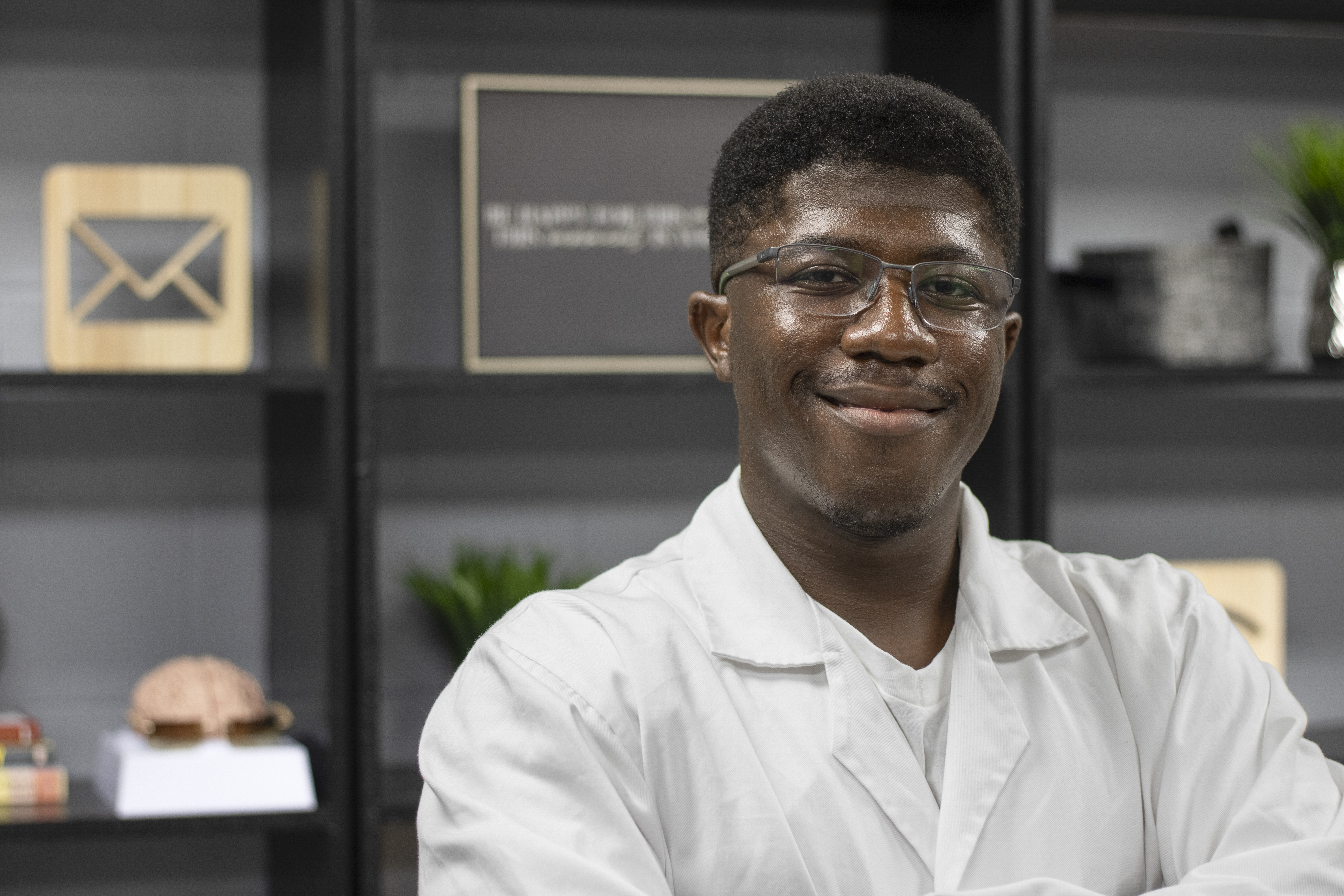Antonio White in a white shirt with black bookshelves in the background