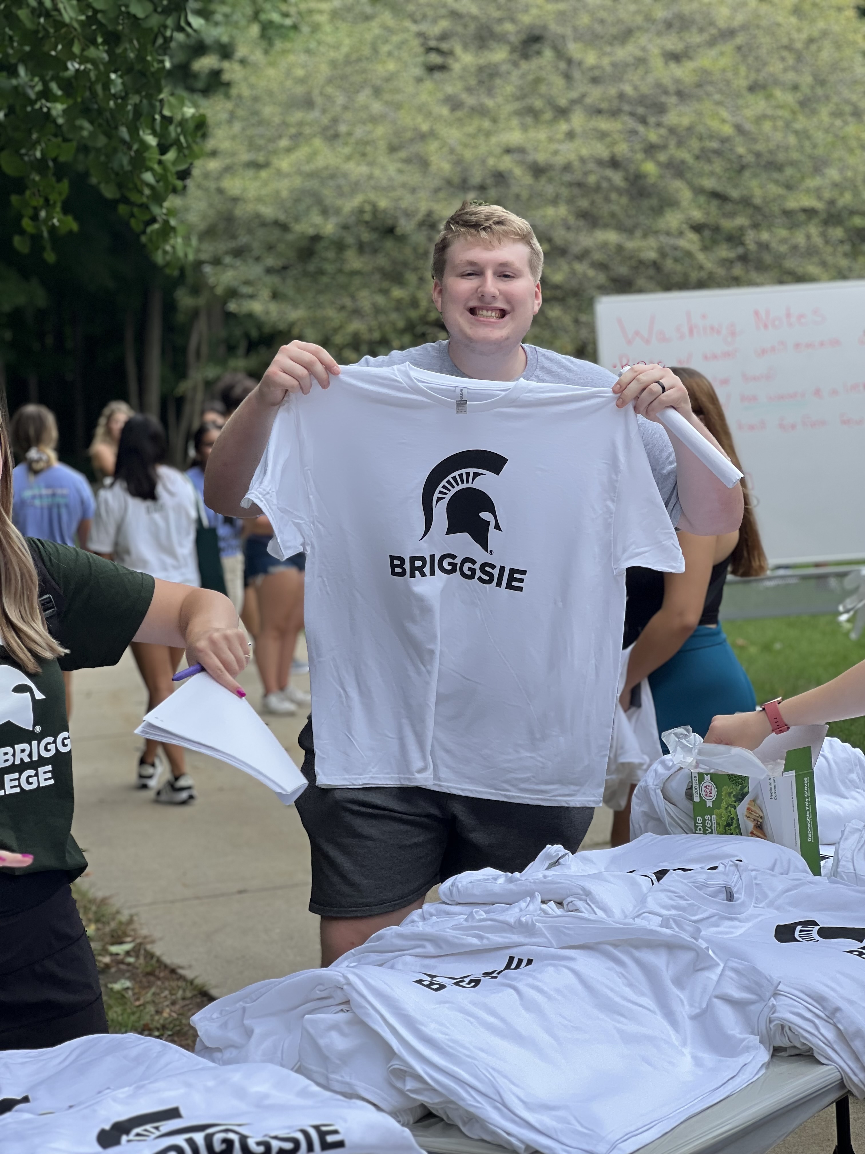 LBC SUTL A student holding up a Spartan t shirt and smiling.