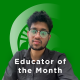 EOTM Deepak James Deepak James in a grey shirt, in front of a green background that reads "Educator of the Month."