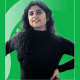 Educator of the Month Shikha Bhutani in front of a green background with the Spartan helmet.
